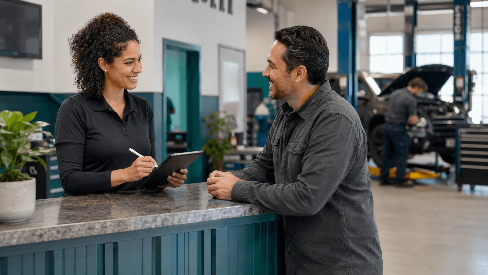 Auto repair service advisor thanking a customer and recording a referral at the service counter